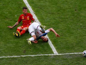 Russia's Maxim Kanunnikov shouts in pain as Belgium's Toby Alderweireld watches during their 2014 World Cup Group H soccer match at the Maracana stadium in Rio de Janeiro June 22, 2014. (REUTERS/Ricardo Moraes)