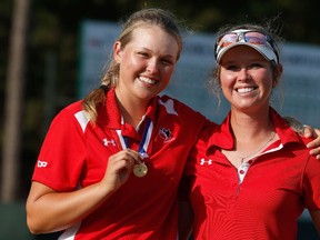 Amateur Brooke Henderson of Canada poses with the Low Amateur medal alongside her sister/caddie Brittany after the final round of the 69th U.S. Women's Open at Pinehurst Resort & Country Club, Course No. 2 on June 22, 2014 in Pinehurst, North Carolina. (Scott Halleran/Getty Images/AFP)