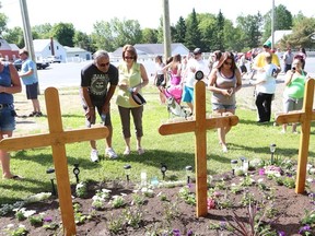 JOHN LAPPA/THE SUDBURY STAR     
A group of people stand at a memorial in Hanmer on Saturday for three teens who were struck and killed by an impaired driver five years ago.