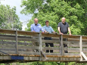 On the bridge along the Fairbank Oil Nature Trail are Charlie Fairbank, left, young Charlie Fairbank, and Art Lucs of Vilnis Cultural Design Works.