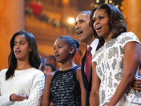 U.S. President Barack Obama (2nd R), his wife Michelle (R) and their daughters Malia (L) and Sasha (2nd L) join performers onstage to sing Christmas carols during a taping of the Christmas in Washington television benefit program at the National Building Museum in Washington December 15, 2013.REUTERS/Jonathan Ernst