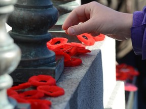 Poppies are left at the Cenotaph in Central Memorial Park in Calgary in this November 11, 2013 file photo. (Stuart Dryden/QMI Agency)