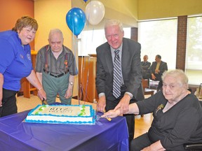 Cutting the cake are Deb Little (left), current board chair; Dick Thorne, president Mitchell Nursing Home and resident council; Howard Famme, an original board member; and Zena Bardecki, president Ritz Lutheran Villa resident council. KRISTINE JEAN/MITCHELL ADVOCATE