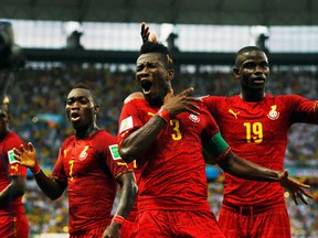Ghana's Asamoah Gyan (centre) dances with teammates Christian Atsu (left) and Jonathan Mensah after scoring against Germany during their World Cup Group G match at Castelao Arena in Fortaleza, Brazil, June 21, 2014. (MARCELO DEL POZO/Reuters)