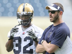 Winnipeg Blue Bombers running back Nic Grigsby (left) and running backs coach Buck Pierce confer during practice.