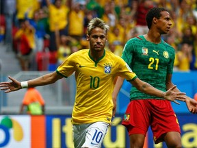 Brazil's Neymar celebrates past Cameroon's Joel Matip after scoring a goal during their World Cup match at the Brasilia national stadium on Monday, June 23, 2014. (Michael Dalder/Reuters)