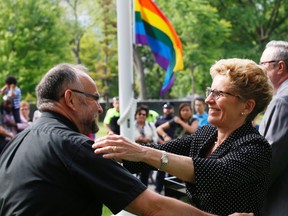 Ontario Premier Kathleen Wynne greets longtime gay activist Rev. Brent Hawkes at a Pride flag raising to mark World Pride being celebrated in Toronto, on the south lawn of Queen's Park  on Monday June 23, 2014. Michael Peake/Toronto Sun/QMI Agency