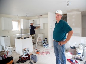 Habitat for Humanity construction manager George De Vlugt is having trouble finding volunteers, such as  Larry Oudekerk behind him, to help put finishing touches on two new homes. (DEREK RUTTAN / The London Free Press)