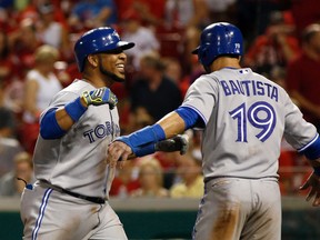 Toronto Blue Jays first baseman Edwin Encarnacion (left) is congratulated by right fielder Jose Bautista after Encarnacion (19) after he hit a three-run home run off Cincinnati Reds relief pitcher Sam LeCure in the ninth inning at Great American Ball Park on Jun 20, 2014 in Cincinnati, OH, USA. (David Kohl/USA TODAY Sports)