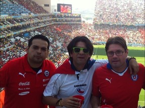 Derek Van Diest, right, poses in the Arena de Sao Paulo with travelling companions Chris Urquijo, left, and Rod Urquijo Monday during the match between Chile and Netherlands. (Derek Van Diest, Edmonton Sun)