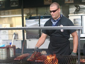 Nathan Diloreto of Smokehouse Bandits of London cooks ribs over a wood fire during the 2013 Chatham-Kent Ribfest held at Tecumseh Park.