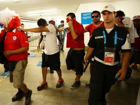 Chile fans are escorted by police after dozens of them crashed a gate to enter Maracana stadium and watch their country play Spain for Group B of the 2014 World Cup, in Rio de Janeiro June 18, 2014. (REUTERS/Dylan Martinez)