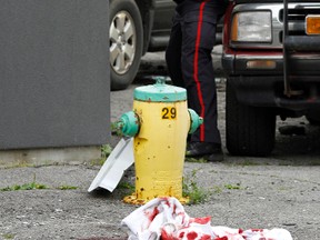 A Belleville police officer photographs the scene where a Carrying Place, Ont. construction worker sustained severe injuries after he fell off the roof of a building at the intersection of Harriett Street and Coleman Street in Belleville, Ont. early Wednesday afternoon, June 25, 2014. - JEROME LESSARD/THE INTELLIGENCER/QMI AGENCY