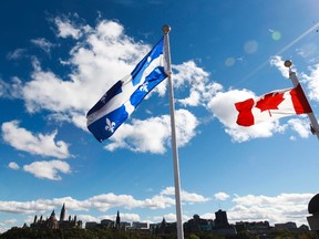 Canadian Flag and Quebec Flag are seen over looking the Ottawa River from the Civilization Museum behind Parliament Hill