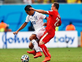 Switzerland's Xherdan Shaqiri fights for the ball with Jorge Claros of Honduras during their World Cup Group E match at Arena Amazonia  in Manaus, Brazil, June 25, 2014. (DOMINIC EBENBICHLER/Reuters)