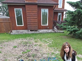 Rose Lutz is seen in her North Kildonan yard on June 25, 2014, with a message left for her by city workers who came out to check if a water leak is the reason behind a patch of rotten grass. (Kevin King/Winnipeg Sun photo)
