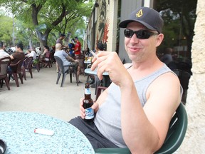 William Kuzych smokes a cigarette on the patio at Bar Italia on Corydon Avenue last month. A survey suggests about two-thirds of Manitobans support extending smoking bans to outdoor patios of restaurants and bars. (Kevin King/Winnipeg Sun file photo)