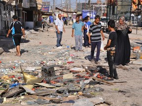 Residents look at the site of a suicide bomber attack in Mahmoudiya, south of Baghdad June 26, 2014. (REUTERS/Ibrahim Sultan)