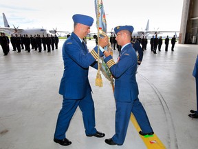 Incoming commanding officer of 426 Transport Training Squadron at 8 Wing/CFB Trenton Lt. Col. Ryan Deming, left, receives the unit's colours from the air base commanding officer, Col. David Lowthian, centre, during a change of command ceremony held in Hangar 1 Thursday, June 26, 2014. - JEROME LESSARD/THE INTELLIGENCER/QMI AGENCY