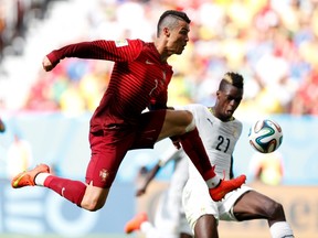 Portugal's Cristiano Ronaldo (left) fights for the ball with Ghana's John Boye during their World Cup match at the Brasilia national stadium on Thursday, June 26, 2014. (Ueslei Marcelino/Reuters)