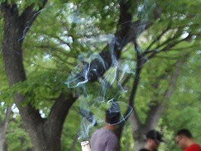 Smoke from a cigarette rises on the patio of Bar Italia on Corydon Avenue in Winnipeg, Man., on Fri., May 30, 2014. A survey suggests about two-thirds of Manitobans support extending smoking bans to outdoor patios of restaurants and bars. Kevin King/Winnipeg Sun/QMI Agency