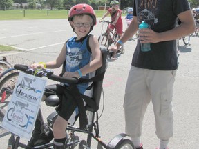 Seven-year-old Zethan Clark and his father Mike pose at the starting line before enjoying a 1.8 km ride around the neighbourhood during the CK Cycling Fest held at Memorial Arena on June 21. The event was a fundraiser to help the Chatham-Kent Children's Treatment Centre Foundation purchase and maintain adapted bicycles.