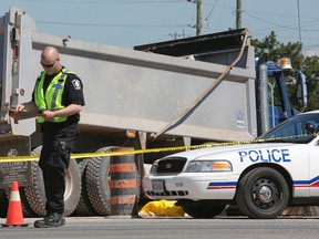 A police officer is pictured at the scene where a construction worker was killed in Milton. (DAVE THOMAS, Toronto Sun)
