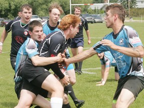 The Sharks (light blue) gang up on a Cold Lake player. - Gord Montgomery, Reporter/Examiner