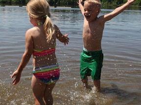Four-year-old twins, Jax and Lexi, splashed away in the water at Mooney's Bay beach — one of four city beaches closed Friday due to high e-coli counts. The reading at Mooney's was 456 e. coli per 100 ml of water — twice what's considered acceptable. Doug Hempstead/Ottawa Sun/QMI Agency