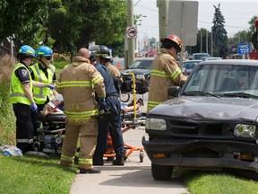 A woman is treated before being taken to hospital after the pickup truck she was in  collided with a car on Wellington Rd. and Emery St. in London on Friday. A man occupant of the truck was also taken to hospital. The two occupants of the car weren't injured. DEREK RUTTAN/ The London Free Press /QMI AGENCY