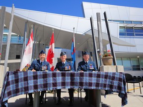 Time to sign official change of command documents at Canadian Forces Aerospace Warfare Centre for, from left, outgoing commanding officer (CO) Col. Martin Cournoyer, Deputy Commander of Royal Canadian Air Force Maj. Gen. R.D. Foster and incoming CO Col. Kelvin Truss during a ceremony held at 8 Wing/CFB Trenton Friday, June 27, 2014. - JEROME LESSARD/THE INTELLIGENCER/QMI AGENCY