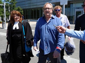 Alan Smith, still wearing his prison ID bracelet, walks past media to a waiting car after he was released from jail on June 27, 2014 when a judge in Oshawa ruled he had been coerced into a confession to an old murder case (Michael Peake/Toronto Sun)