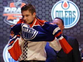 Leon Draisaitl pulls on an Oilers jersey Friday during the NHL Entry Draft at the Wells Fargo Center in Philadelphia. (USA Today Sports)