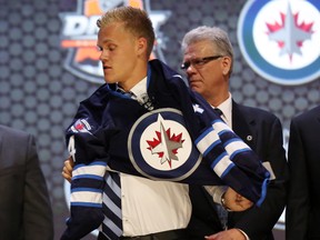 Nikolaj Ehlers puts on a team sweater after being selected as the number nine overall pick to the Winnipeg Jets in the first round of the 2014 NHL Draft at Wells Fargo Center. Mandatory Credit: Bill Streicher-USA TODAY Sports