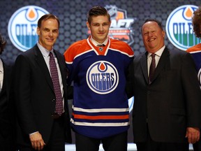 Leon Draisaitl poses on the stage with Oilers senior v-p of hockey opperations Scott Howson and head scout Stu MacGregor on stage at the Wells Fargo Centre during the NHL Entry Draft in Philadelphia Friday. (USA Today)