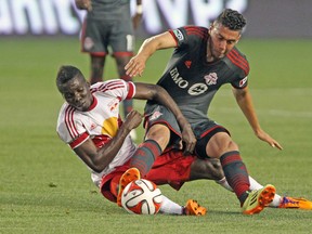 Toronto FC midfielder Jonathan Osorio tangles with New York Red Bulls’ Ambroish Oyongo during last night’s game in Harrison, N.J. (USA  TODAY SPORTS)