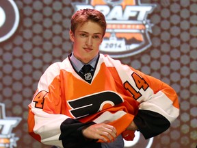 Jun 27, 2014; Philadelphia, PA, USA; Travis Sanheim puts on a team sweater after being selected as the number seventeen overall pick to the Philadelphia Flyers in the first round of the 2014 NHL Draft at Wells Fargo Center. Mandatory Credit: Bill Streicher-USA TODAY Sports