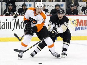 Apr 12, 2014; Pittsburgh, PA, USA; Philadelphia Flyers left wing Michael Raffl (12) skates with the puck as Pittsburgh Penguins left wing Jussi Jokinen (36) chases during the first period at the CONSOL Energy Center. Mandatory Credit: Charles LeClaire-USA TODAY Sports