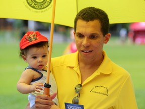 Javier Clavelo, who immigrated to Ottawa from Cuba where he was a journalist, keeps his son Sebastian in the shade during the Community Cup at Brewer Park on Saturday, june 28, 2014. More than 2,000 people were expected to attend the event, which is put on annually to help newcomers to the city and country meet and make new friends. (Chris Hofley/Ottawa Sun)