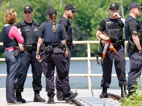 Members of the OPP Underwater Search and Recovery Unit are seen at the Trent River damn north of Frankford in Quinte West, Ont. as the search for Umana Gonzalo, 47, of Toronto, Ont. resumes Sunday morning, June 29, 2014. - JEROME LESSARD/THE INTELLIGENCER/QMI AGENCY