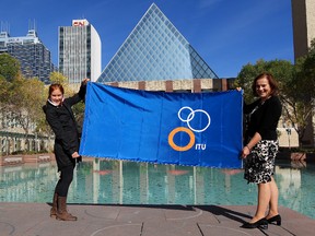 Edmonton triathlete Paula Findlay and City Councillor Jane Batty display an International Triathlon Union (ITU) flag outside Edmonton City Hall, in Edmonton, Alta., Thursday Sept. 19, 2013. The two raised an ITU flag at City Hall Thursday to mark the transfer of Grand Final host duties from London to Edmonton. Edmonton will host the event in Hawrelak Park from August 26 to Sept. 2, 2014. David Bloom/Edmonton Sun/QMI Agency