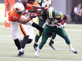 Edmonton Eskimos' Eddie Steele (right) pushes off BC Lions’ Torri Williamsn (left) as he runs down field during the second half of CFL game at BC Place in Vancouver, B.C. on Saturday June 28, 2014. Carmine Marinelli/QMI Agency