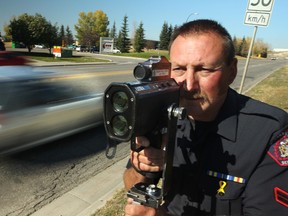 Calgary City Police traffic section Cst. Jim Lebedeff demonstrates a laser speed gun to illustrate speeding along Deerfoot Trail in Calgary, Alberta, on September 27,  2012. MIKE DREW/CALGARY SUN/QMI AGENCY