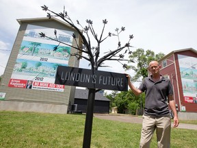 A black metal tree, with a sign reading 'London's Future', stands outside of Arnon Kaplansky's towers on Huron Street in London, Ontario on Monday June 30, 2014.  Kaplansky, who has a long history of battling with city planners, has erected large banners on the sides of two towers, depicting the renderings he had previously submitted to city hall showing the buildings he had hoped to build on the site.
CRAIG GLOVER/The London Free Press/QMI Agency
