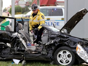 Police investigate at the scene of a two vehicle collision at the 156 Street and 111 Avenue intersection, in Edmonton Alta., on Monday June 30, 2014. A 30-year-old woman is in hospital with life-threatening injuries after her Toyota sedan collided with a truck. David Bloom/Edmonton Sun/QMI Agency