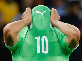 Algeria's Sofiane Feghouli covers his face with his jersey as he reacts to his team's loss at the end of their World Cup game against Germany at the Beira Rio stadium in Porto Alegre, Brazil on Monday, June 30, 2014. (Edgard Garrido/Reuters)