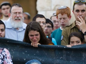 A woman mourns during a memorial service for U.S.-Israeli national Naftali Fraenkel, 16, one of three Israeli teens who were abducted and killed in the occupied West Bank, before his funeral, in the central Israeli village of Nof Ayalon July 1, 2014.  REUTERS/Baz Ratne