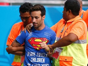 A fan is escorted out during the World Cup game between Belgium and the U.S. at the Fonte Nova arena in Salvador, Brazil on Tuesday, July 1, 2014. (Marcos Brindicci/Reuters)