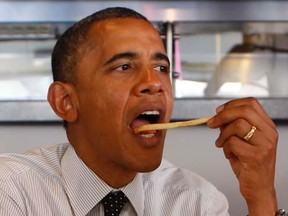 U.S. President Barack Obama eats a French fry as he holds a round table discussion with first time voters at OMG Burger in Miami, Florida September 20, 2012.  REUTERS/Kevin Lamarque