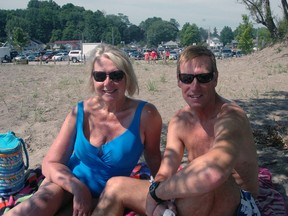 Gayle Russell and boyfriend Alan Leek sit under a tree at Main Beach in Port Stanley on Monday.